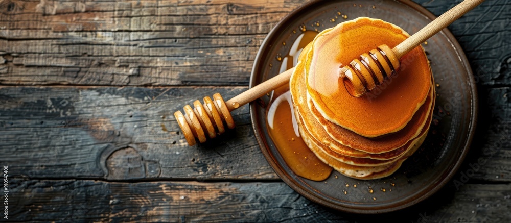 Poster wooden table with pancakes drizzled in honey featuring ample copy space image