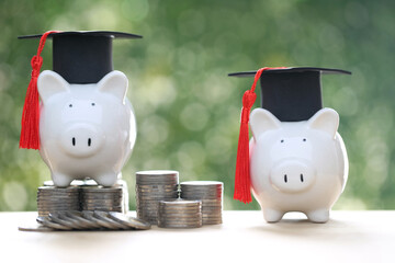 Graduation hat on piggy bank with stack of coins money on nature green background, Saving money for education concept 
