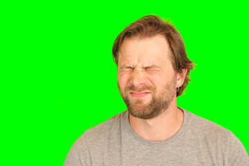 Upset man over plain green background. Adult bearded fun confused shy shamed bemused guy. Green...