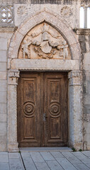 A historic wooden door in a stone archway