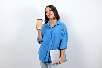 Well-groomed woman in a blue shirt drinks coffee during a break in the office, business portrait