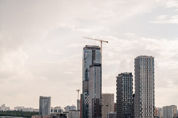 Obraz premium Construction site of a block of flats of the monolithic residential apartment building against blue sky. Tower cranes.
