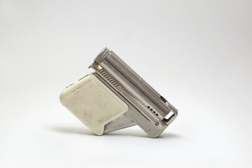 vintage petrol lighter, in pistol style design. ajar, handle with plastic linings, pocket cigarette lighter