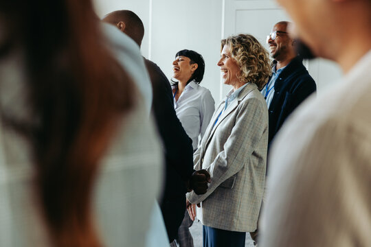 Business professionals laughing together during a conference event, creating a positive and engaging atmosphere