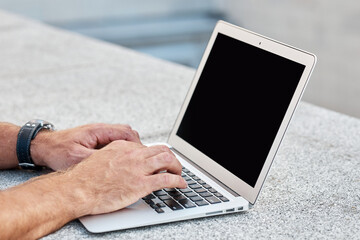 Man working using laptop on the street, close-up of laptop screen with copy space