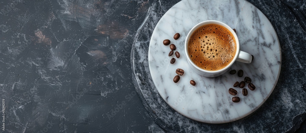 Poster top view of a cup of coffee and coffee beans on a marble tray against a dark backdrop is shown in th