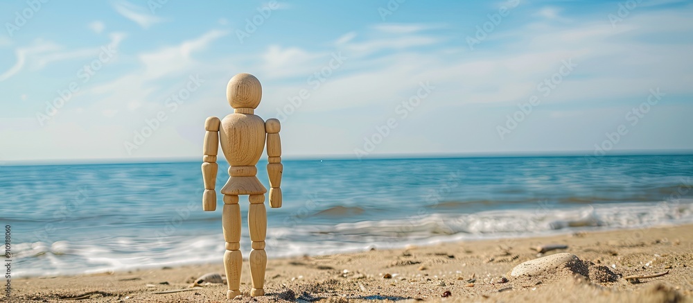 Aufkleber wooden mannequin on a sandy beach with ocean in background during summer perfect for copy space imag