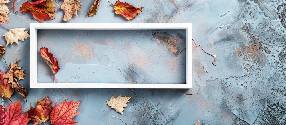 Poster White photo frame with autumn dried leaves on an autumn background creates a flat lay top view ideal for seasonal promotions with copy space image