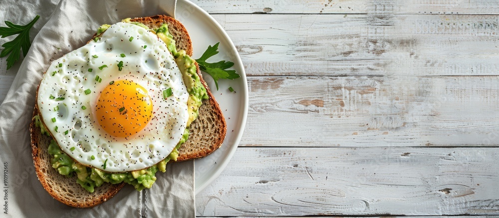 Poster healthy breakfast with avocado toast fried egg and whole grain bread presented on a white wooden sur
