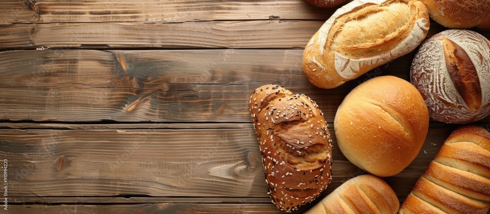 Poster Various types of freshly baked bread on a rustic wooden table with copy space image