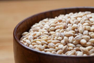 Peeled barley in a wooden bowl on the table