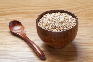 Peeled barley in a wooden bowl on the table