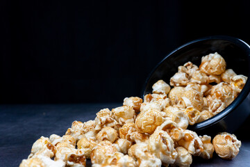 scattered popcorn from bowl with black background