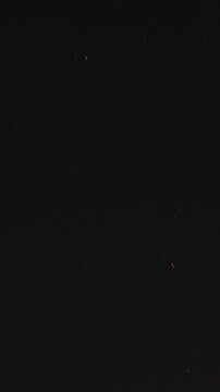 Vertical Time lapse shot of Moon in the sky during the night as seen from Naggar near Manali in Himachal Pradesh, India. Night Lapse shot of moonset along with stars in the mountains.