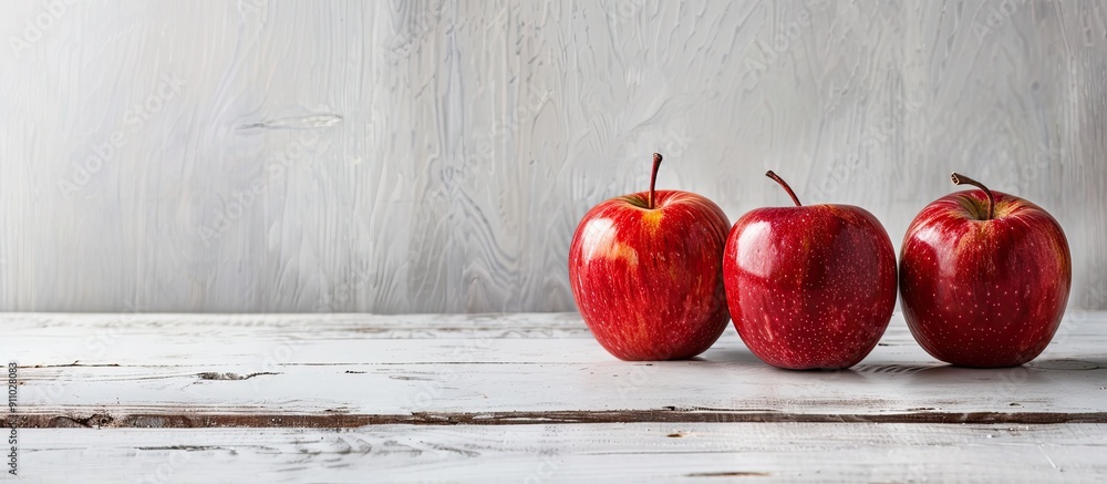 Poster three apples displayed on a white wooden table with empty copy space image.