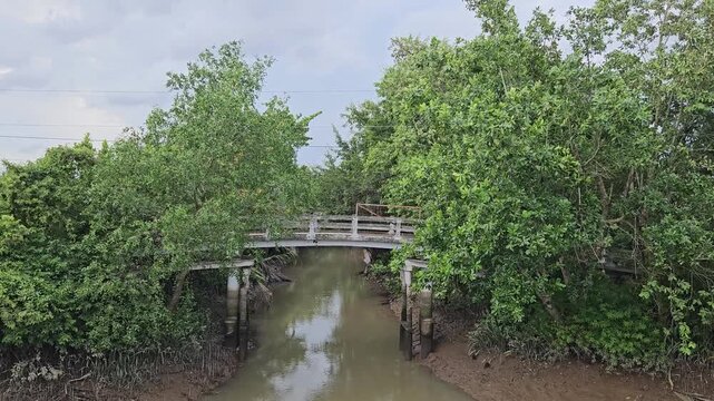 4k panning shot of small river and small bridge at mang Thit district, Vinh Long province, Vietnam. Tropical village landscape concept.