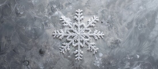 Fototapeta premium White fluffy snowflake Christmas decoration against a gray backdrop perfect for New Year's and Christmas greetings, with an overhead perspective and room for adding text or images