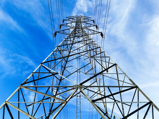 Aerial view High voltage with beautiful clouds sky. Photo for industrial use, electrical power systems. High-voltage power transmission poles for remote areas and rural area. Environment and energy 