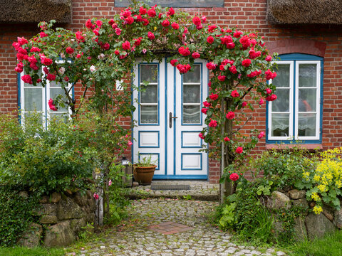  Flowers blooming in front of rustic brick house