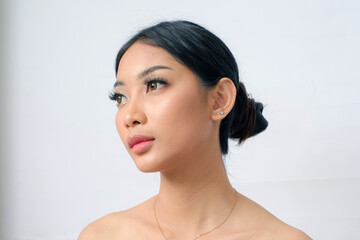 Closed Up Elegant Southeast Asian Woman with Glowing Brown Skin and Bun Hairstyle on White Background