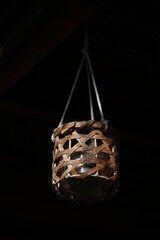 Candle hanging off rope in darkness