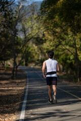 A man is running on a path in a forest