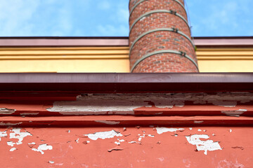 Building exterior with wall damage, including cracked plaster and chipped paint, revealing the...