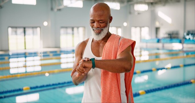 Senior, black man or time at swimming pool for fitness, resting heart rate or ready for exercise. Male swimmer, smart watch or towel at aquatic gym for health, hydrotherapy or activity in retirement