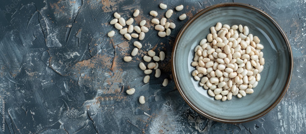 Poster top view of a plate with raw white beans on a table with a copy space image