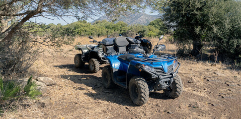 Two-seater quad bikes and passengers take a break from their safari in Dorgali in central Sardinia