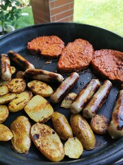grilled sausages meat and potatoes