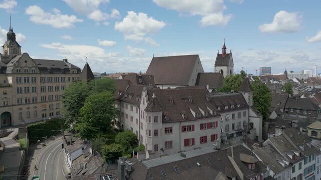 4K Drone Video of Church Bell Towers, Historic Buildings, and Construction Cranes in downtown Basel, Switzerland (Pan Left)