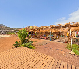 Colourful shot of glamping lounge with cacti and sand creating an apocalyptic ambiance similar to that of burning man or mad max