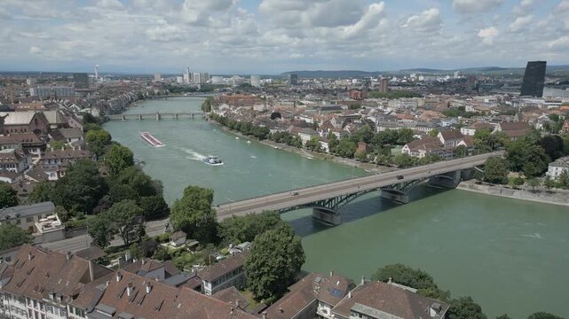 4K Drone Video of Tugboat Pulling Barge Towards the Wettsteinbr&uuml;cke Bridge over the Rhine River in Basel, Switzerland (Track Left)