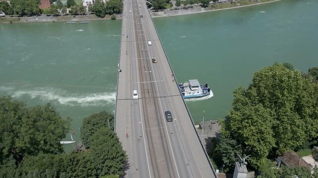 4K Drone Video of Tugboat on the Rhine River Going Under the Wettsteinbr&uuml;cke Bridge in Basel, Switzerland (Track Left)