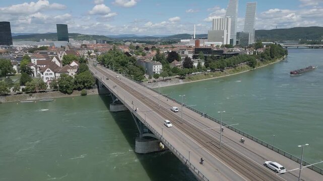 4K Drone Video of Tugboat Pulling Oil Barge Under the Wettsteinbr&uuml;cke Bridge over the Rhine River in Basel, Switzerland