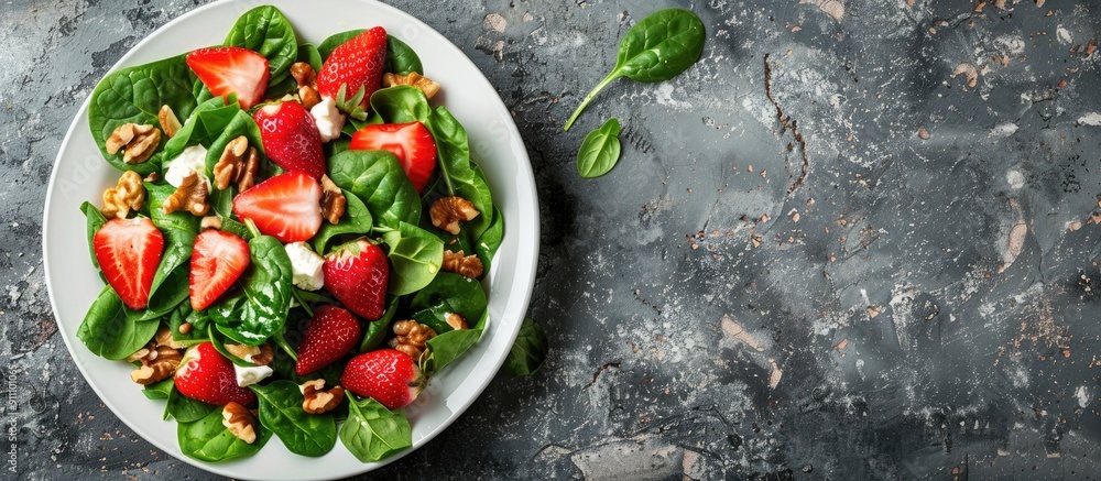 Poster fresh strawberries spinach cream cheese and walnuts create a light healthy summer salad displayed on