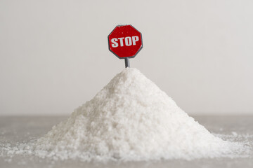 Red stop sign on pile of white salt. Concept of giving up salt.