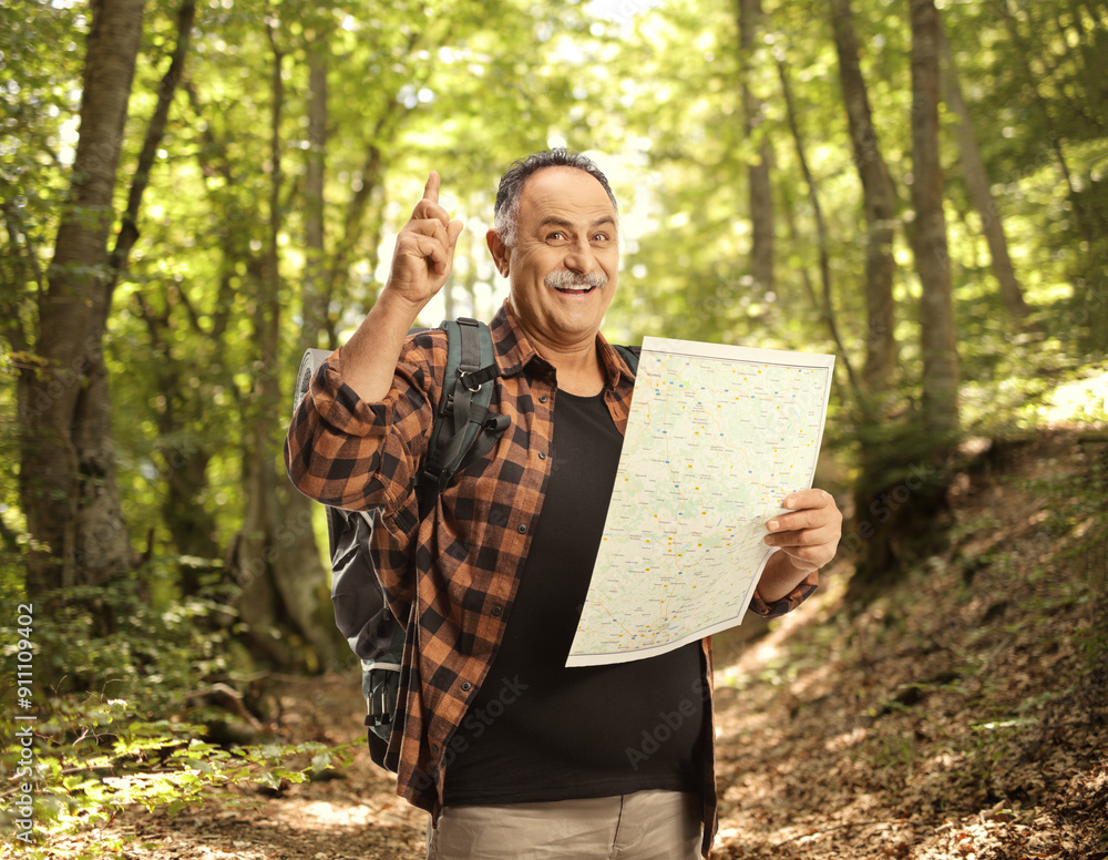 Sticker Smiling mature hiker holding a map and pointing