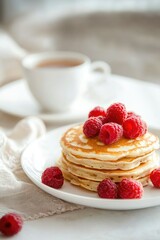 pancakes with raspberries and a cup of tea. Selective focus