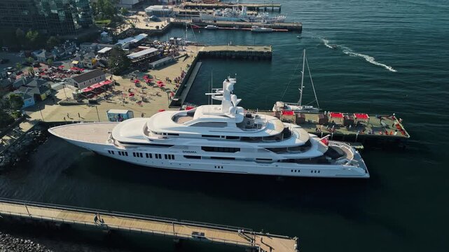 Drone Shot Golden hour over Halifax harbor with the Yacht Samsara docked, cityscape and sunset reflections blending seamlessly in this stunning aerial view. Canada, Nova Scotia. 