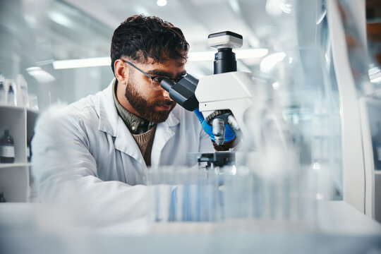 Healthcare, man and scientist with microscope in lab of experiment research, medical data or studying bacteria. Researcher, check and biotechnology for pharmaceutical development of vaccine solution