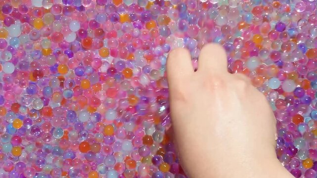 The girl's hand moves smoothly, in a circular motion, a lot of multicolored hydrogel balls. Videos for anti-stress and rest and relaxation. Asmr. Part 2
