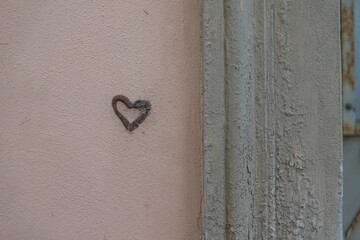 Kleines Herzgraffiti an einer Hauswand – reduzierte Nahaufnahme eines stillen Liebessymbols im...