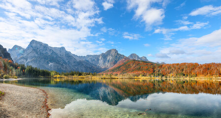 Breathtaking autumn scene of sunny morning on Almsee lake.