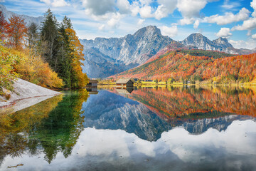 Breathtaking autumn scene of sunny morning on Almsee lake.