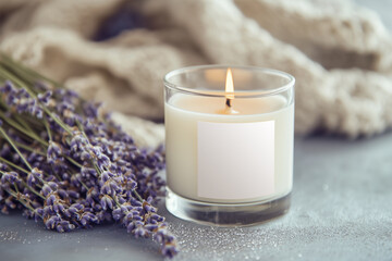 Candle in glass with a blank label, on table with fresh lavender. Styled photo product mockup