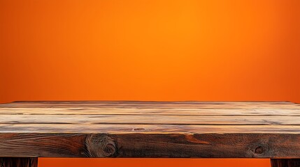 Empty wooden table on abstract orange background for product presentation, space for a montage showing the product