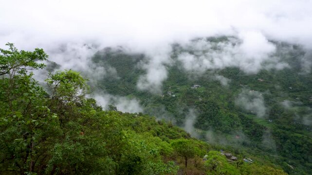 A beautiful scenic view of Almora valleys and mountains covered in clouds during the monsoon season in Uttarakhand, India.
