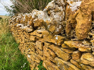 Close-up of an old dry stonewall covered in lichen